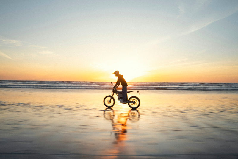 E-Bike-Fahrer am Strand bei Sonnenuntergang